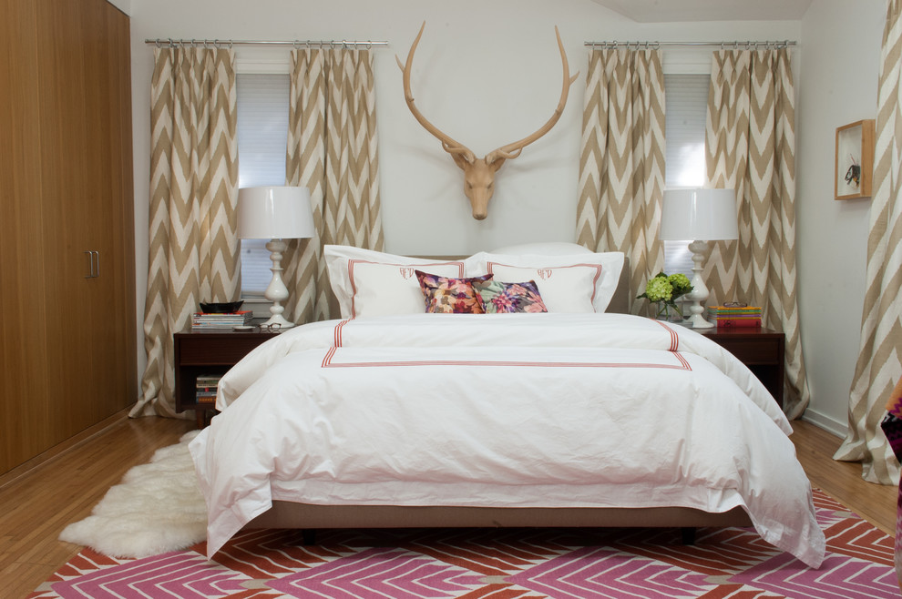 Eclectic bedroom in Dallas with white walls and medium hardwood floors.