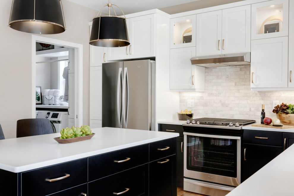 Example of a mid-sized transitional l-shaped medium tone wood floor and brown floor eat-in kitchen design in Minneapolis with an undermount sink, recessed-panel cabinets, black cabinets, quartz countertops, beige backsplash, stone tile backsplash, stainless steel appliances, an island and white countertops