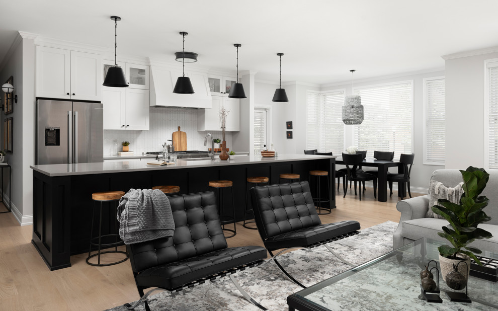 Open concept kitchen - mid-sized transitional galley light wood floor open concept kitchen idea in Chicago with an undermount sink, shaker cabinets, white cabinets, quartz countertops, white backsplash, ceramic backsplash, stainless steel appliances, an island and gray countertops