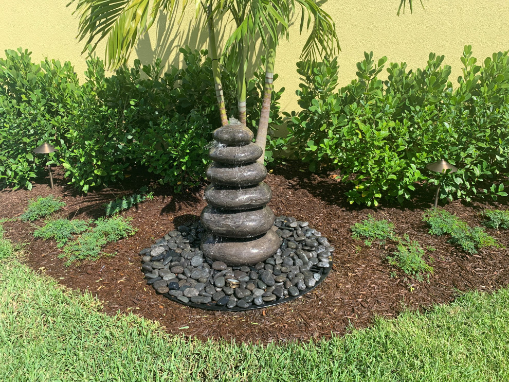 Photo of a small transitional backyard garden in Miami with a water feature.