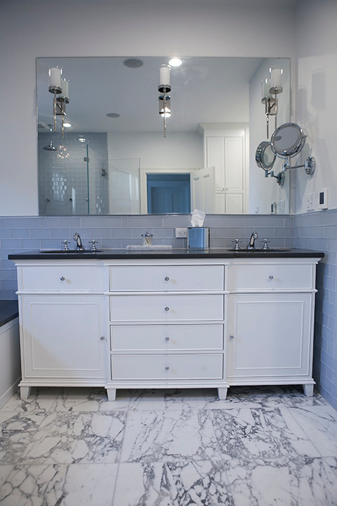 Inspiration for a large transitional master bathroom in New York with flat-panel cabinets, white cabinets, a corner tub, a corner shower, white tile, white walls and marble floors.