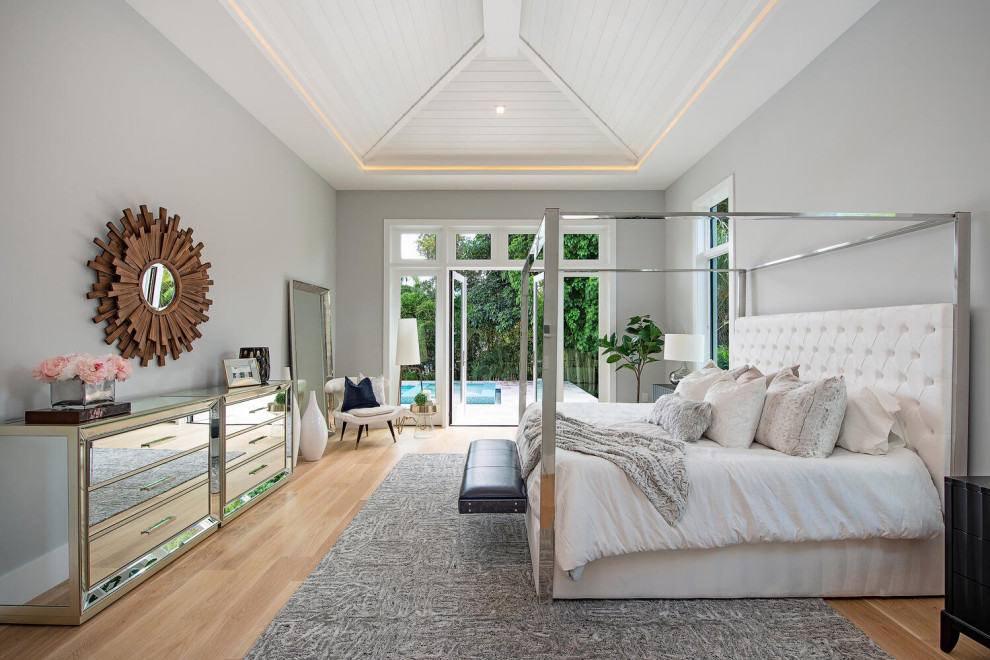 Mid-sized beach style master bedroom in Other with grey walls, laminate floors and vaulted.