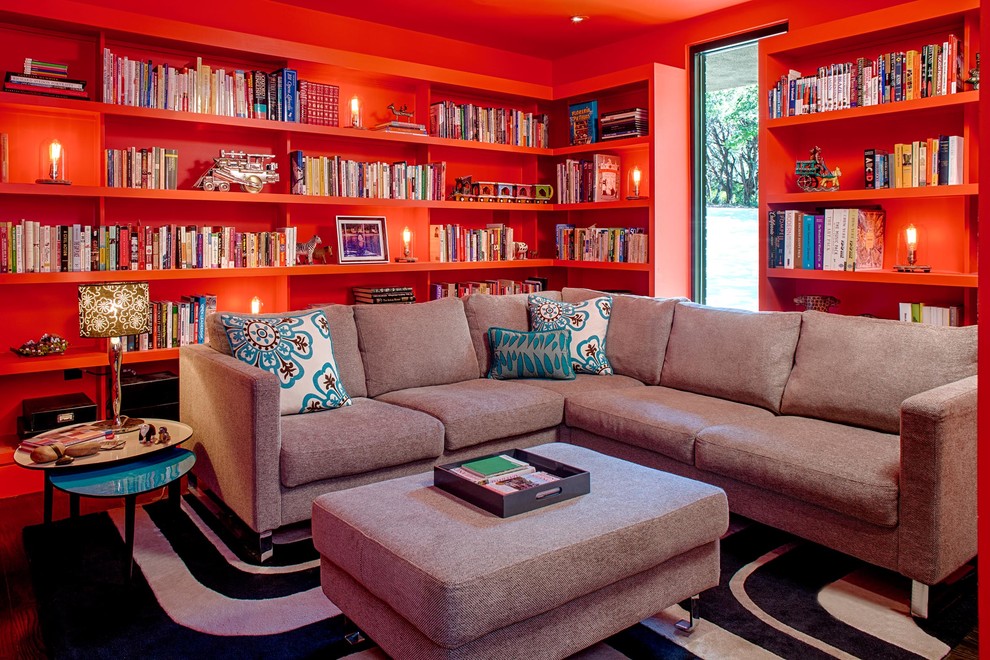 Photo of a contemporary family room in Austin with a library and red walls.