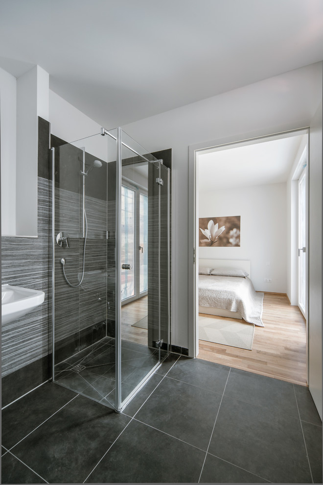 Inspiration for a mid-sized contemporary master bathroom in Berlin with a corner shower, gray tile, white walls, stone tile and slate floors.
