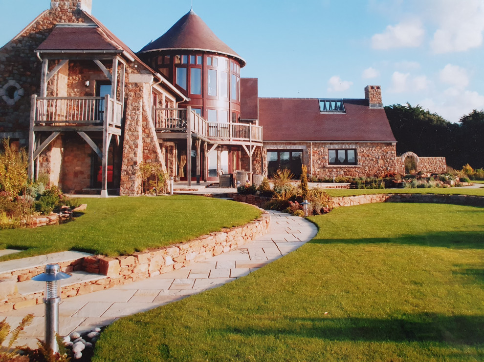 Design ideas for a huge traditional drought-tolerant, rock and full sun stone landscaping for summer.