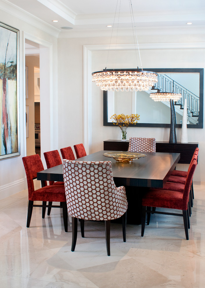 This is an example of a contemporary dining room in Miami with white walls and marble floors.