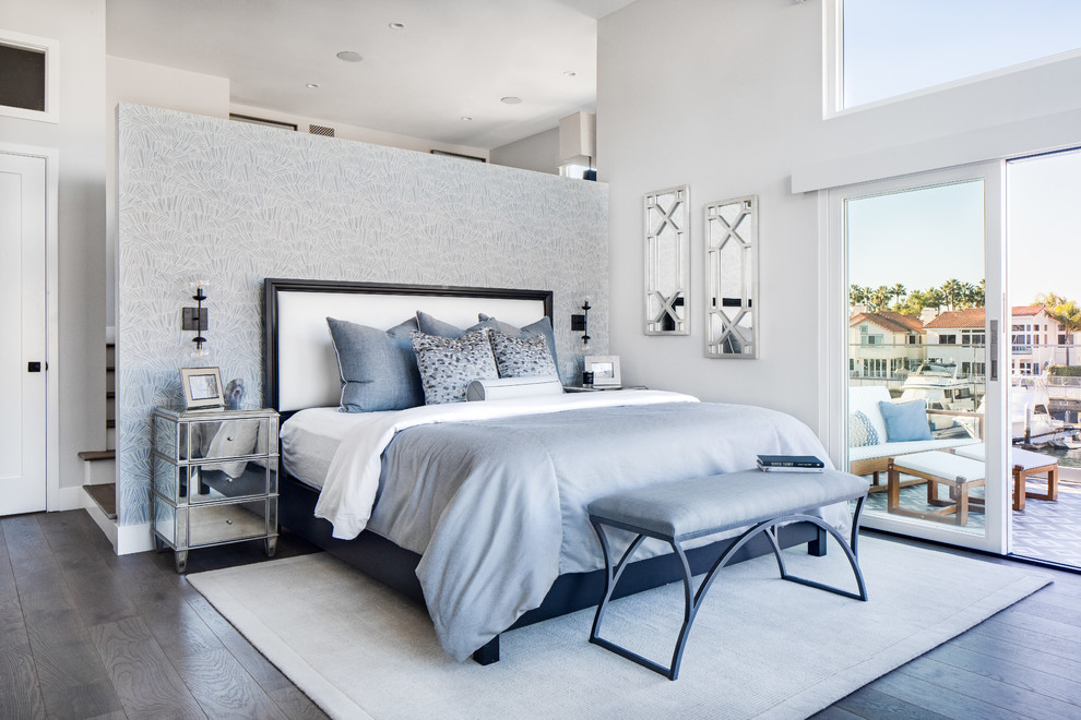Photo of a mid-sized beach style master bedroom in Los Angeles with grey walls, medium hardwood floors and brown floor.