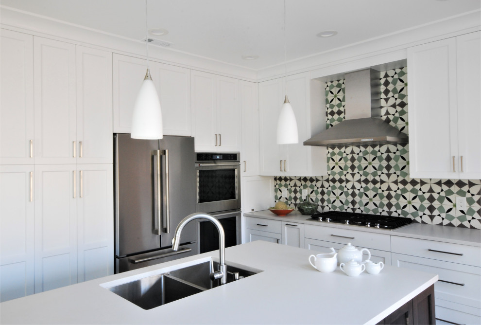 Inspiration for a mid-sized transitional l-shaped porcelain tile and gray floor kitchen remodel in Philadelphia with an undermount sink, shaker cabinets, white cabinets, quartz countertops, green backsplash, porcelain backsplash, stainless steel appliances, an island and white countertops