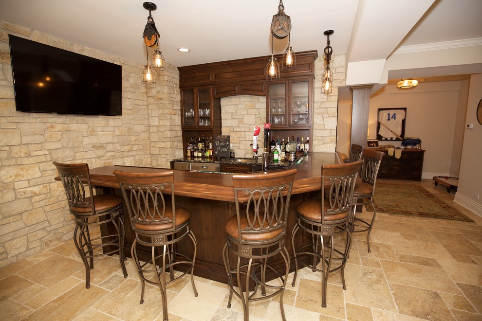 Inspiration for a large arts and crafts u-shaped seated home bar in Chicago with an undermount sink, raised-panel cabinets, medium wood cabinets, granite benchtops, beige splashback, stone tile splashback, travertine floors and beige floor.