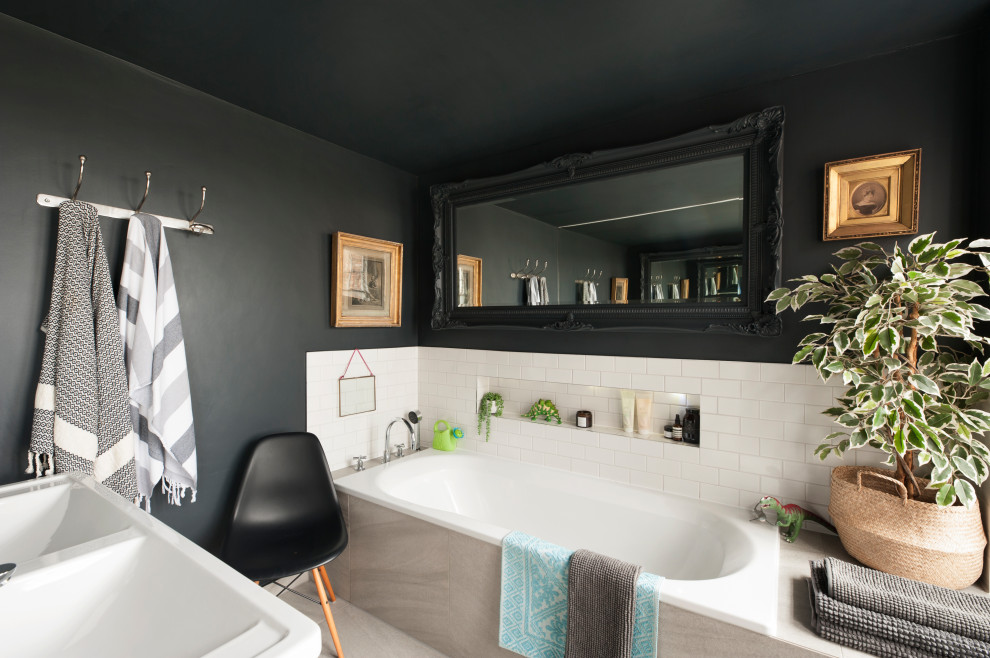 Inspiration for a traditional bathroom in Los Angeles with a drop-in tub, white tile, subway tile, black walls, marble floors and a double vanity.