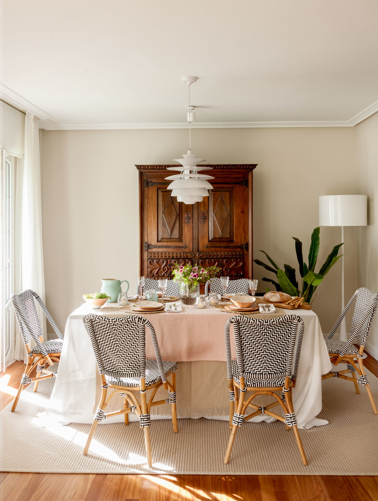 Modelo de comedor clásico renovado con paredes beige, suelo de madera en tonos medios y suelo marrón