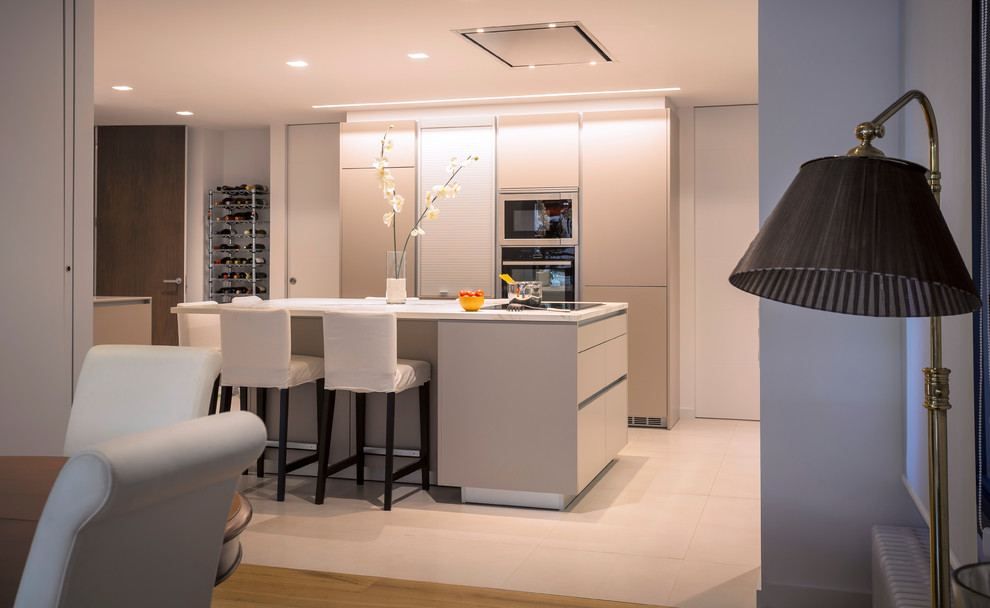 Inspiration for a large contemporary u-shaped open plan kitchen in Barcelona with a double-bowl sink, flat-panel cabinets, beige cabinets, stainless steel appliances, ceramic floors, with island and beige floor.