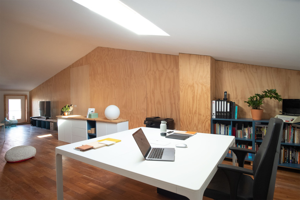 Идея дизайна: рабочее место среднего размера в современном стиле с белыми стенами, паркетным полом среднего тона, отдельно стоящим рабочим столом, коричневым полом и деревянными стенами