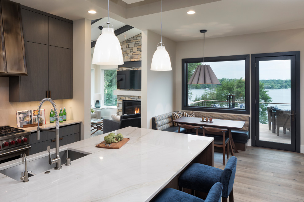 Inspiration for a mid-sized modern single-wall open plan kitchen in Minneapolis with an undermount sink, flat-panel cabinets, grey cabinets, quartz benchtops, grey splashback, marble splashback, panelled appliances, light hardwood floors, with island, beige floor and white benchtop.