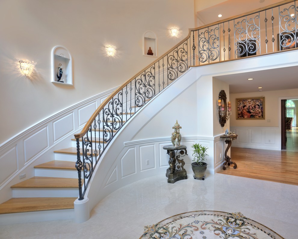 Photo of a large traditional wood curved staircase in Boston with painted wood risers.