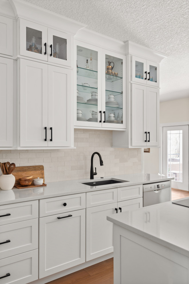 Transitional brown floor kitchen photo in Orlando with quartzite countertops, white backsplash, ceramic backsplash, stainless steel appliances, an island and white countertops