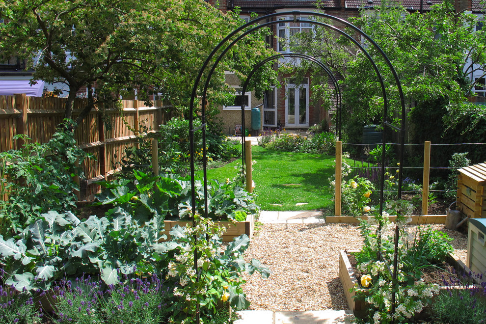 Mid-sized traditional backyard full sun garden in London with a vegetable garden and gravel for summer.