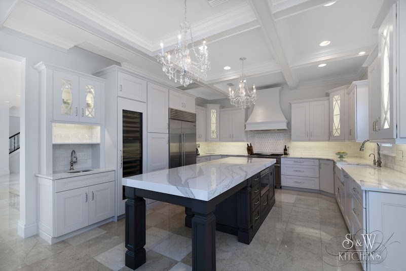Design ideas for a large contemporary u-shaped open plan kitchen in Tampa with a farmhouse sink, recessed-panel cabinets, white cabinets, quartz benchtops, white splashback, stone tile splashback, stainless steel appliances, marble floors and with island.