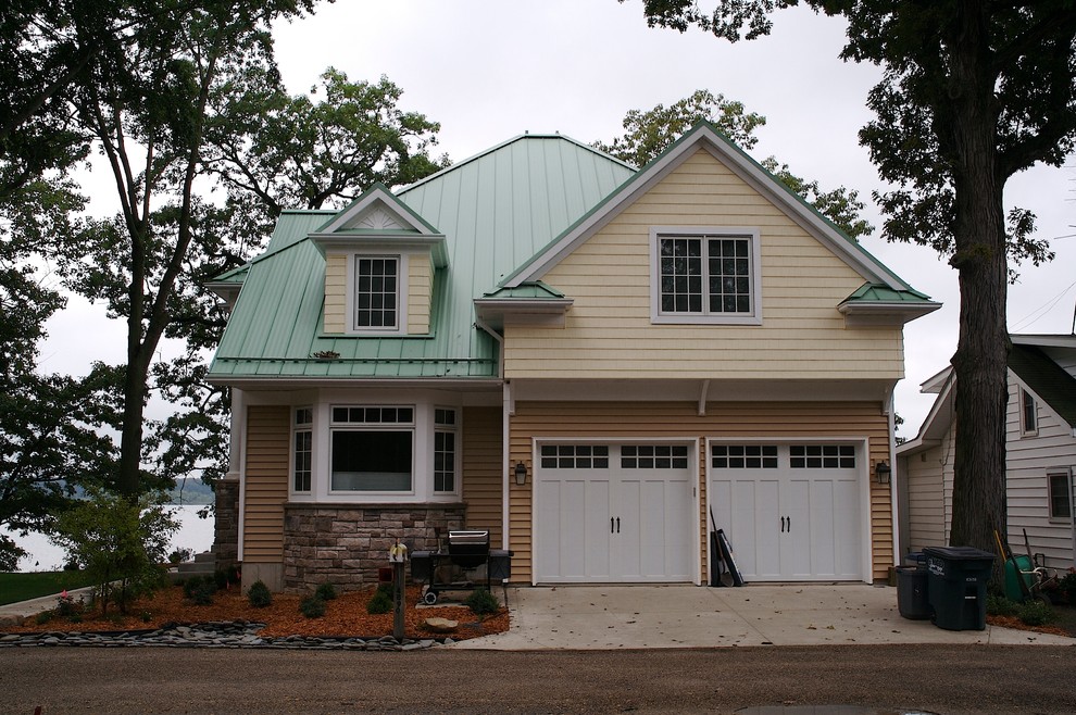 Small beach style three-storey yellow exterior in Cleveland with mixed siding.