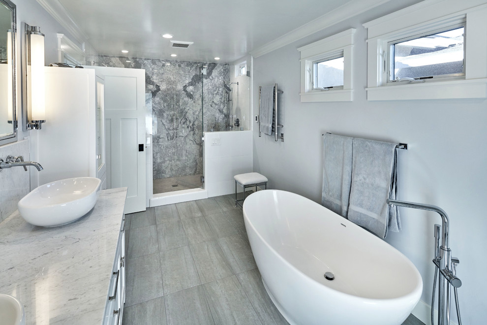Large transitional master bathroom in San Francisco with shaker cabinets, white cabinets, a freestanding tub, a double shower, a wall-mount toilet, white tile, subway tile, grey walls, limestone floors, a vessel sink and marble benchtops.