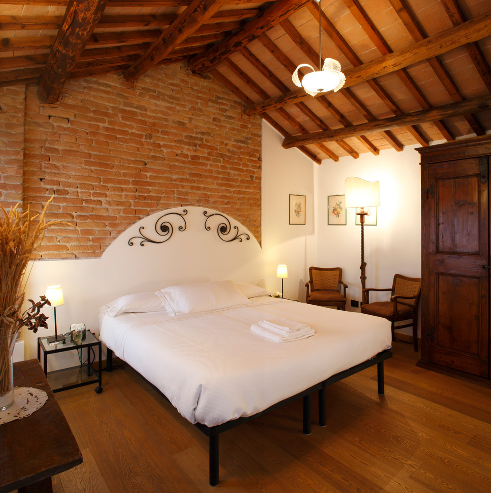 Ejemplo de habitación de invitados campestre sin chimenea con paredes beige y suelo de madera oscura
