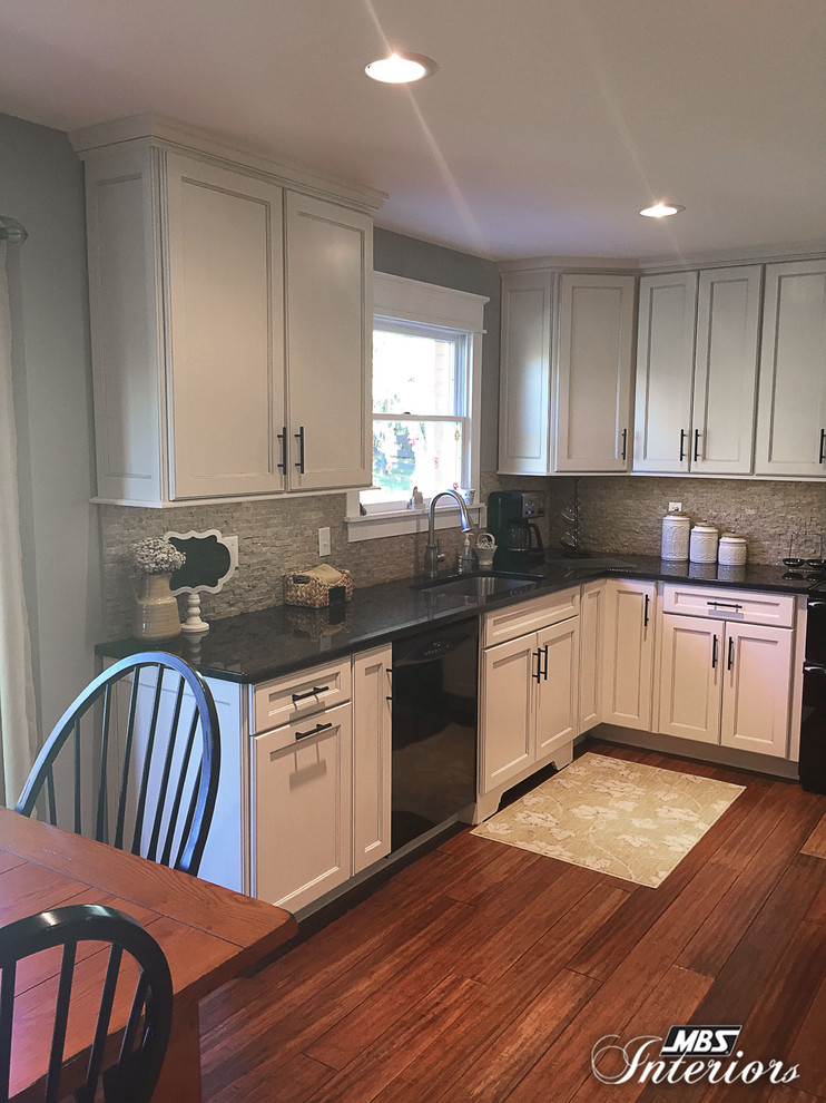 Eat-in kitchen - mid-sized transitional u-shaped medium tone wood floor eat-in kitchen idea in Cincinnati with an undermount sink, flat-panel cabinets, white cabinets, granite countertops, gray backsplash, stone tile backsplash, black appliances and no island