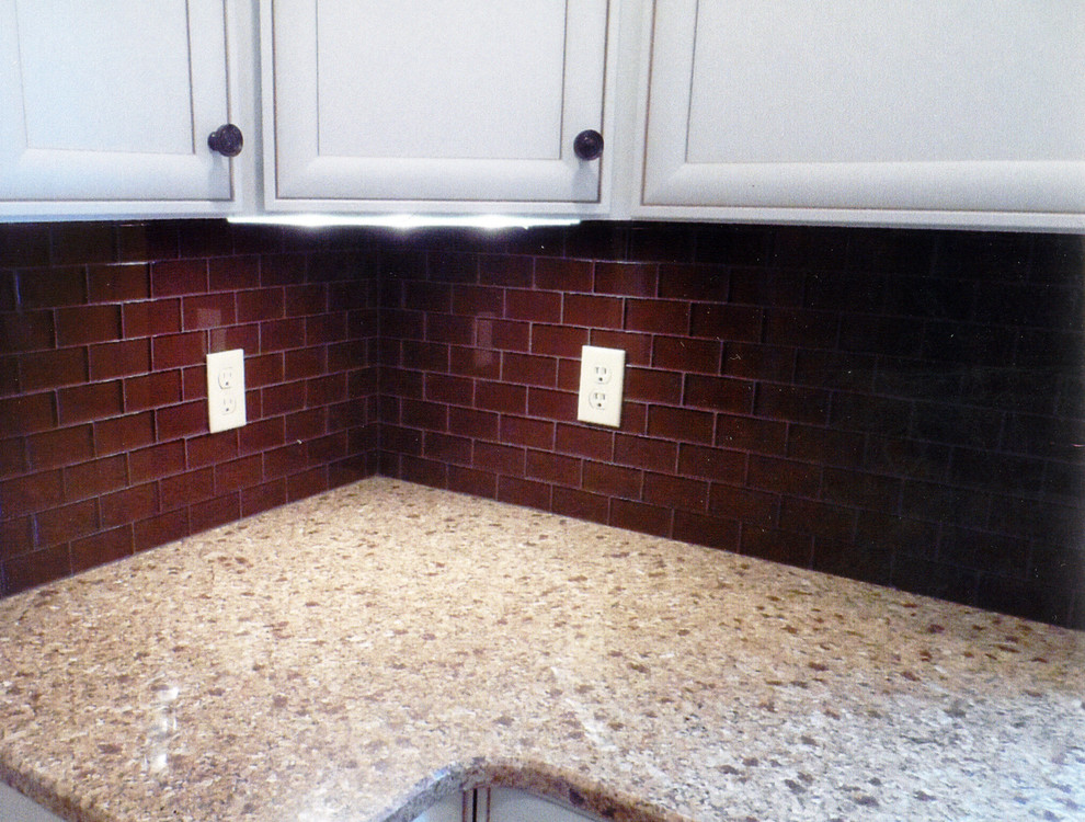 Mid-sized transitional l-shaped laminate floor and yellow floor kitchen pantry photo with an undermount sink, recessed-panel cabinets, white cabinets, granite countertops, brown backsplash, ceramic backsplash, stainless steel appliances, no island and beige countertops