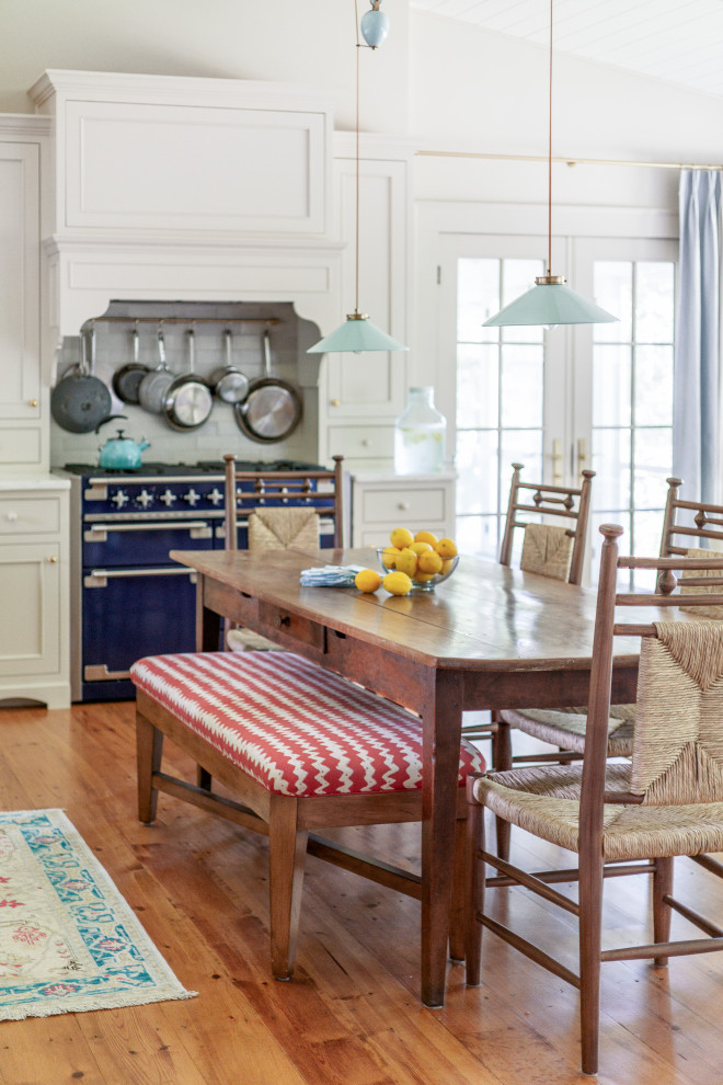 Example of a transitional vaulted ceiling open concept kitchen design in Boston with a farmhouse sink, recessed-panel cabinets, beige cabinets, marble countertops, colored appliances, no island and white countertops