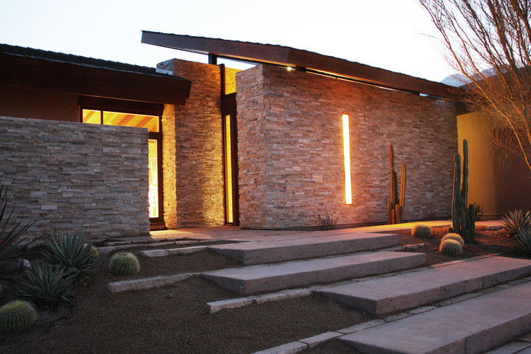 Inspiration for a large contemporary one-storey beige exterior in Los Angeles with stone veneer and a gable roof.