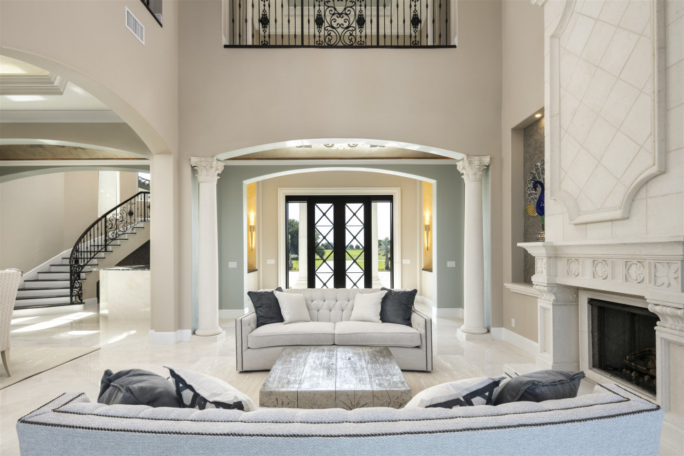 Cette photo montre un très grand salon tendance ouvert avec une salle de réception, un mur beige, un sol en marbre, une cheminée standard, un manteau de cheminée en béton, un sol beige et un plafond décaissé.