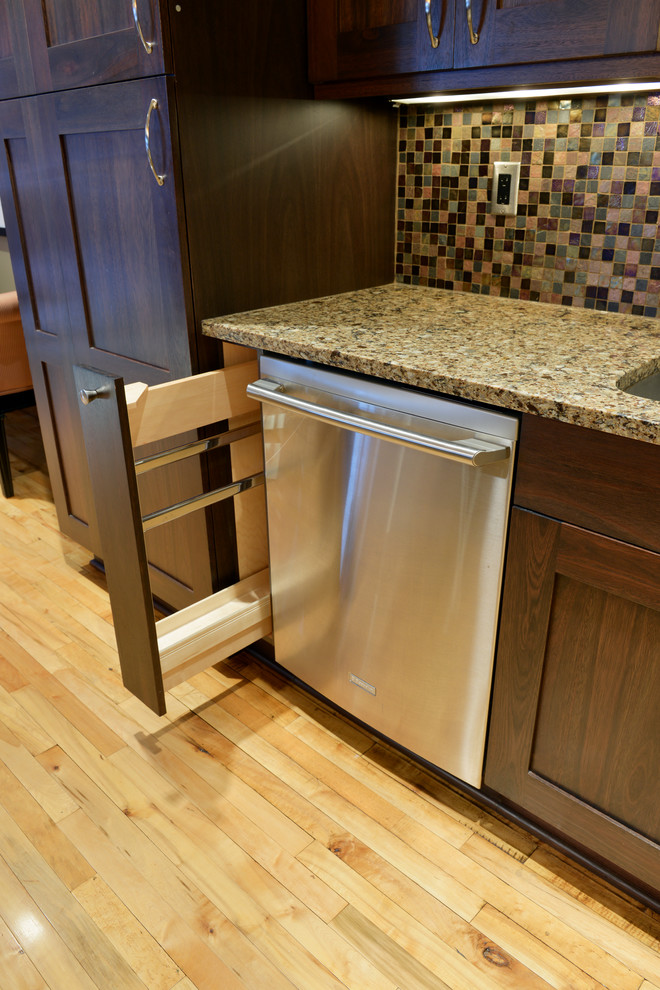 Mid-sized transitional l-shaped light wood floor open concept kitchen photo with an undermount sink, shaker cabinets, dark wood cabinets, quartzite countertops, multicolored backsplash, mosaic tile backsplash, stainless steel appliances and an island