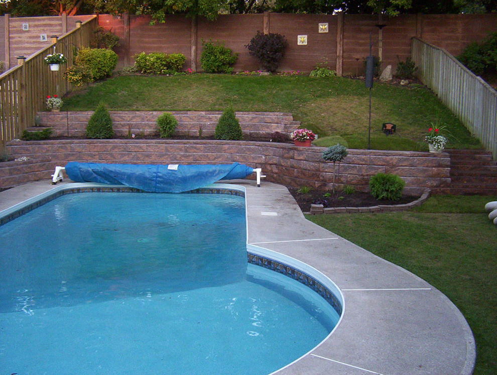 Inspiration for a mid-sized backyard concrete paver and freeform pool remodel