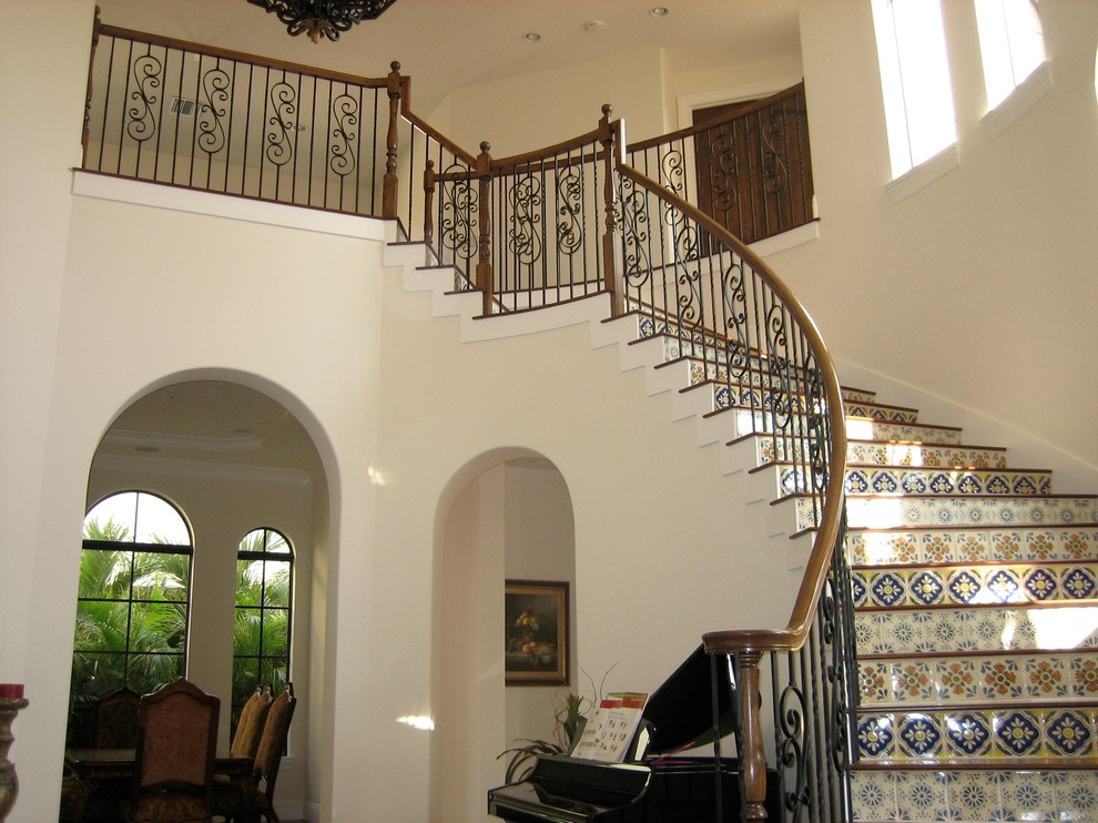 Photo of an eclectic wood curved staircase in Miami with tile risers.