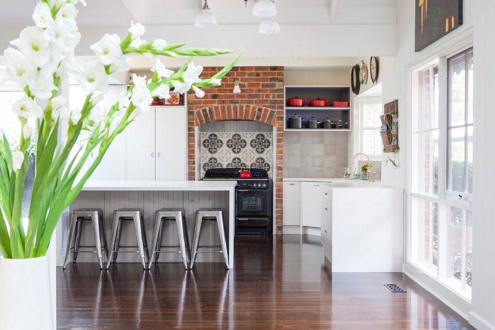 This is an example of a large country eat-in kitchen in Melbourne with dark hardwood floors and with island.