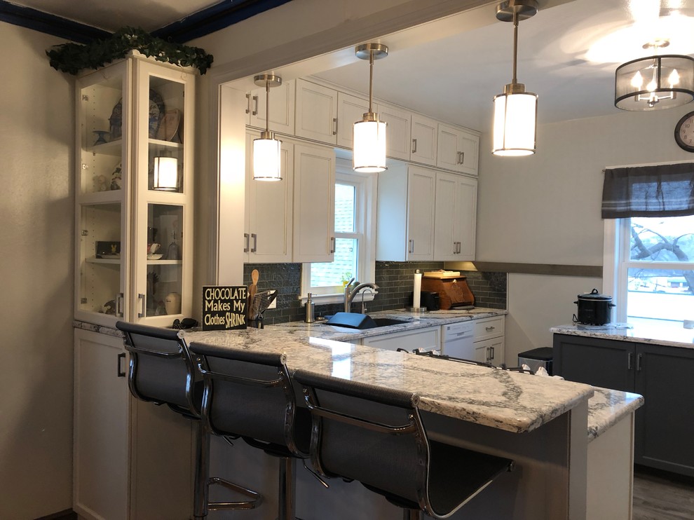 Inspiration for a small transitional l-shaped laminate floor and gray floor eat-in kitchen remodel with an undermount sink, flat-panel cabinets, white cabinets, quartz countertops, gray backsplash, subway tile backsplash, white appliances and white countertops