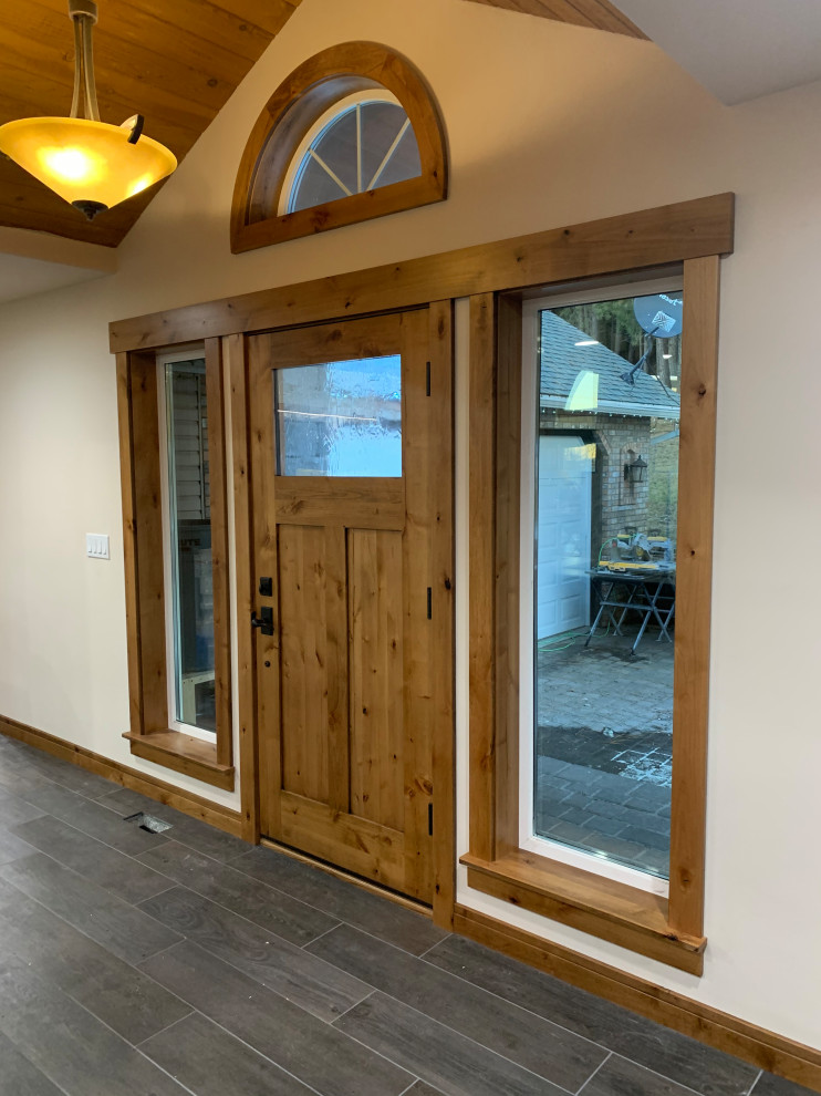 Front door - large craftsman porcelain tile and gray floor front door idea in Boise with white walls and a medium wood front door