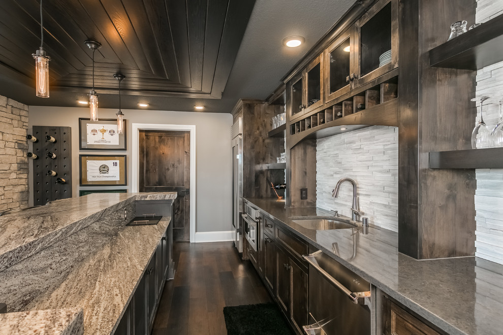 Large modern single-wall seated home bar in Minneapolis with an undermount sink, shaker cabinets, distressed cabinets, granite benchtops, white splashback, matchstick tile splashback, dark hardwood floors, brown floor and white benchtop.
