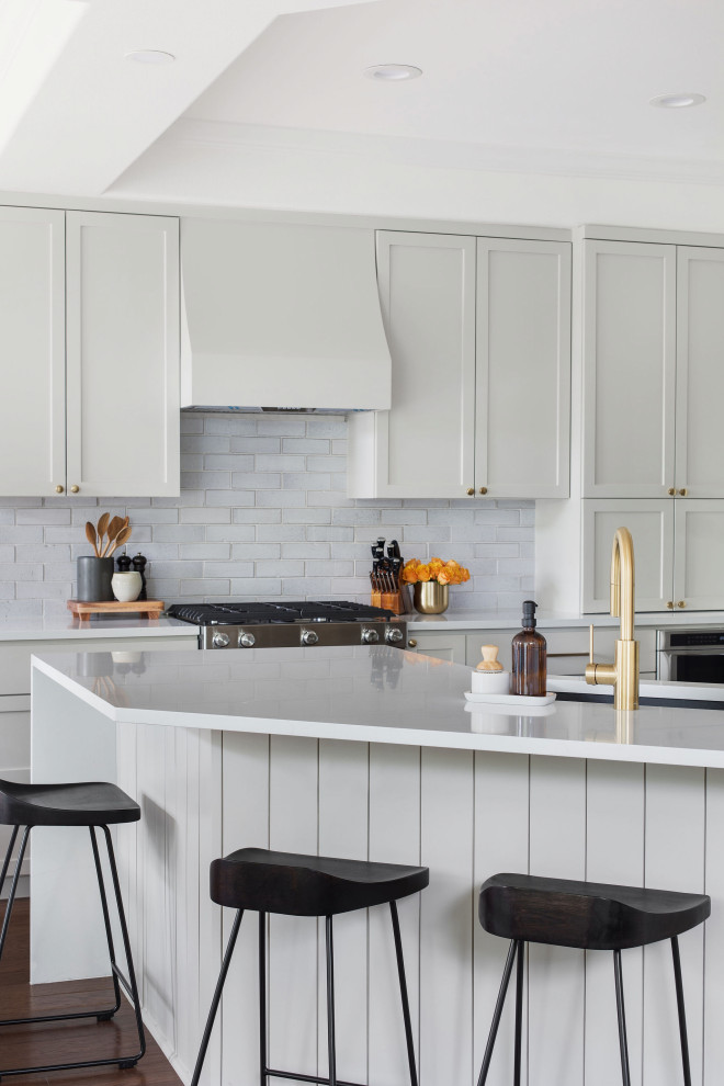 Mid-sized transitional medium tone wood floor and brown floor kitchen photo in Austin with an undermount sink, shaker cabinets, gray cabinets, quartz countertops, white backsplash, brick backsplash and white countertops