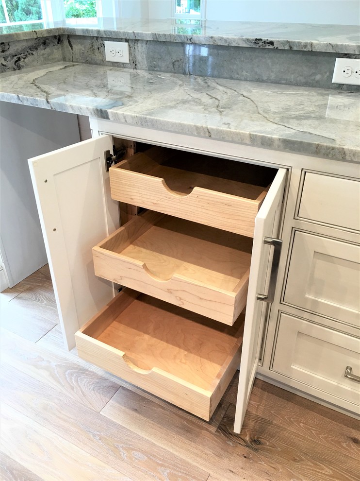 Eat-in kitchen - large transitional l-shaped medium tone wood floor and brown floor eat-in kitchen idea with an undermount sink, flat-panel cabinets, gray cabinets, marble countertops, gray backsplash, marble backsplash, paneled appliances and an island