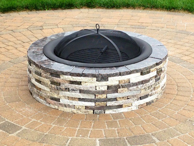 Photo of a traditional backyard patio in Detroit with a fire feature and natural stone pavers.