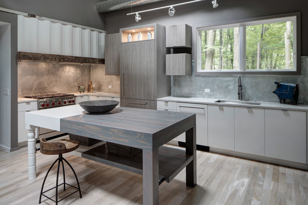 This is an example of a mid-sized contemporary l-shaped kitchen in Chicago with an undermount sink, flat-panel cabinets, white cabinets, grey splashback, stainless steel appliances, light hardwood floors, with island, stone slab splashback, solid surface benchtops and beige floor.