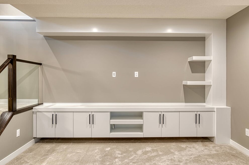 Example of a mid-sized transitional walk-out carpeted and gray floor basement design with gray walls and no fireplace