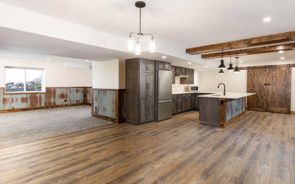 Inspiration for a large rustic look-out vinyl floor, brown floor and wainscoting basement remodel in Denver with a bar, beige walls, a wood stove and a stone fireplace