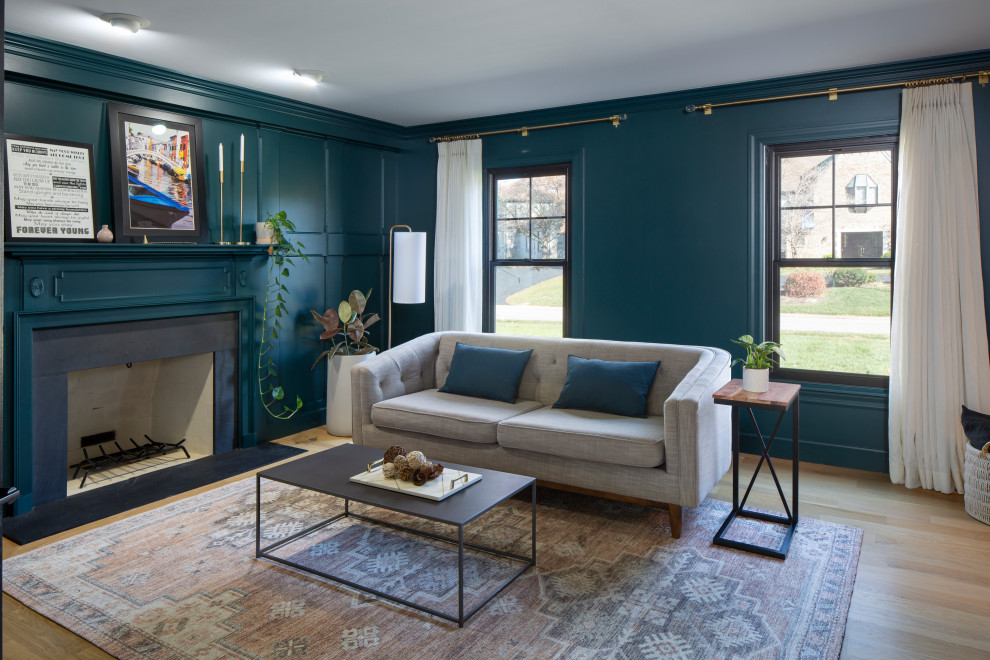 Mittelgroßes Modernes Wohnzimmer mit grüner Wandfarbe, hellem Holzboden, Kamin, Kaminumrandung aus Holz und Wandpaneelen in Cincinnati