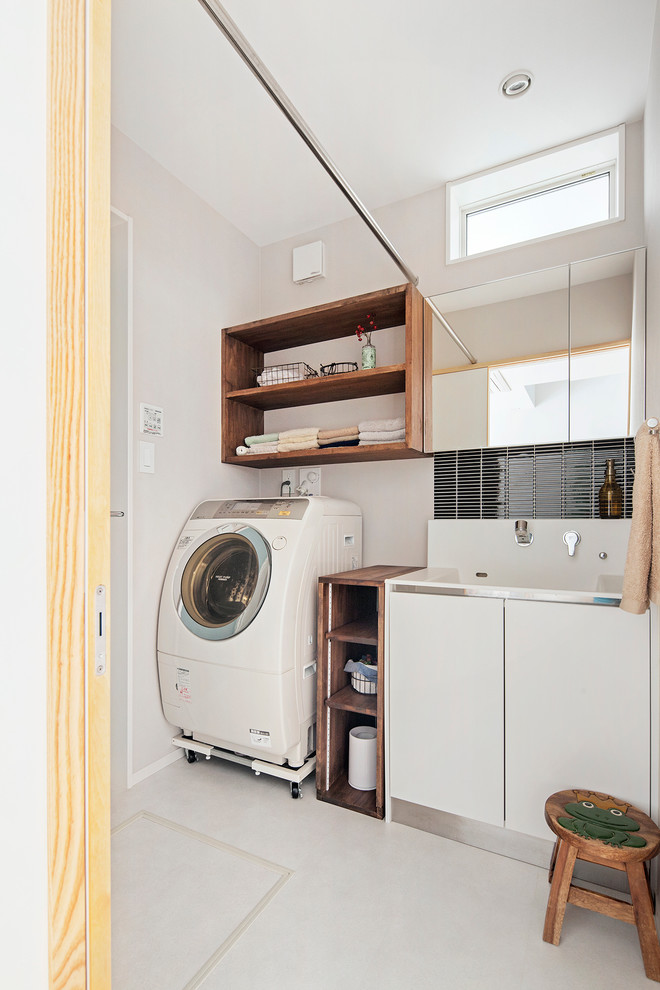 Inspiration for a contemporary single-wall dedicated laundry room in Other with flat-panel cabinets, white walls, white cabinets and an integrated washer and dryer.