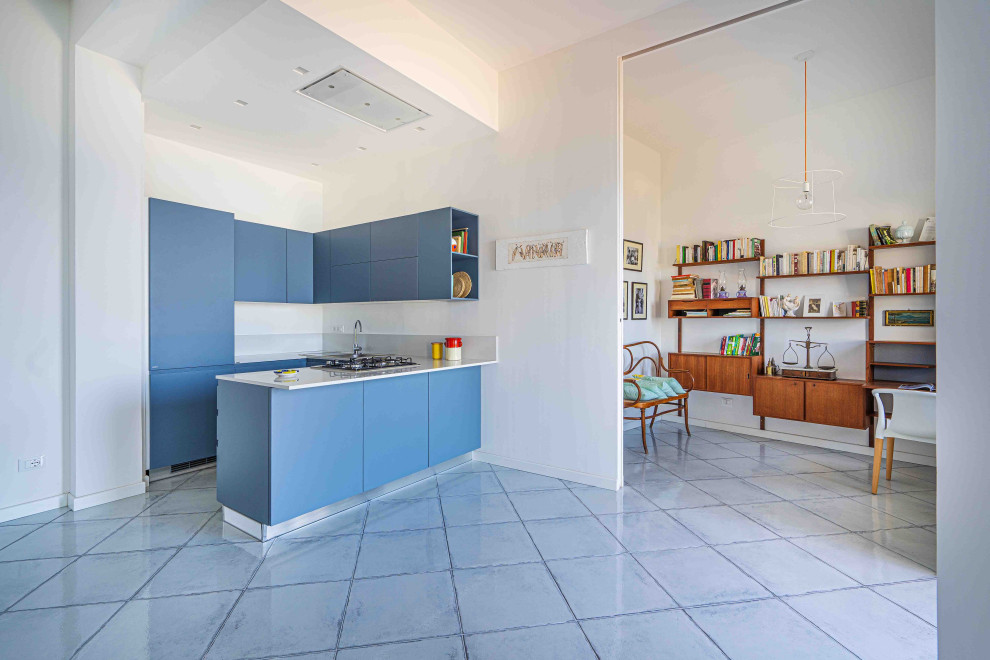 This is an example of a large mediterranean u-shaped open plan kitchen in Naples with a drop-in sink, beaded inset cabinets, solid surface benchtops, white splashback, stainless steel appliances, ceramic floors, no island, white benchtop, recessed, turquoise cabinets, marble splashback and turquoise floor.