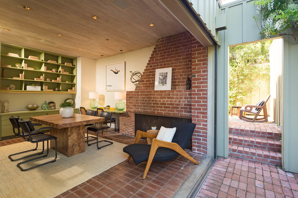 This is an example of a midcentury separate dining room in Los Angeles with a brick fireplace surround.