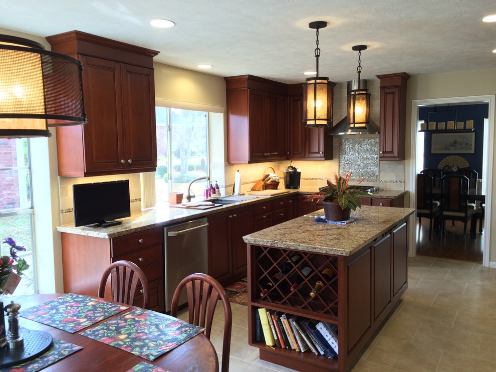 This is an example of a mid-sized traditional l-shaped eat-in kitchen in Houston with an undermount sink, raised-panel cabinets, dark wood cabinets, granite benchtops, beige splashback, stone tile splashback, stainless steel appliances, porcelain floors, with island and beige floor.