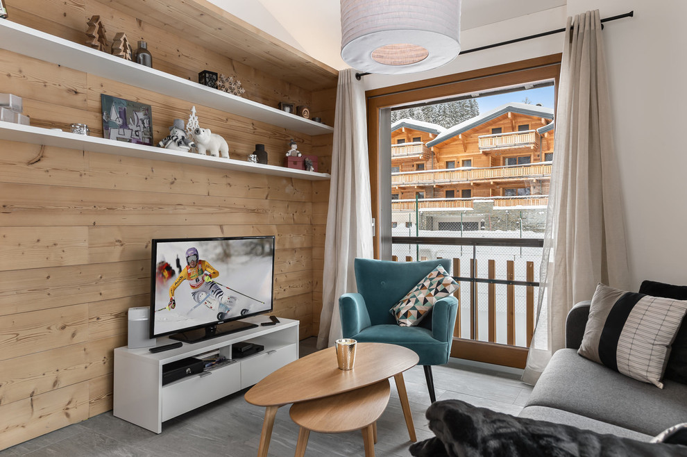 Idée de décoration pour un salon chalet fermé avec un mur blanc, un téléviseur indépendant et un sol gris.