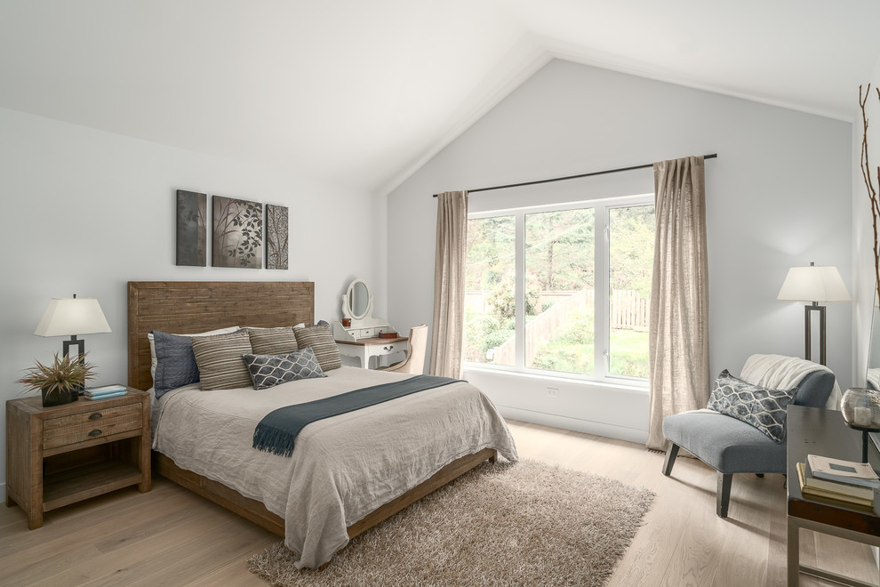 This is an example of a mid-sized transitional master bedroom in Vancouver with white walls, light hardwood floors and beige floor.